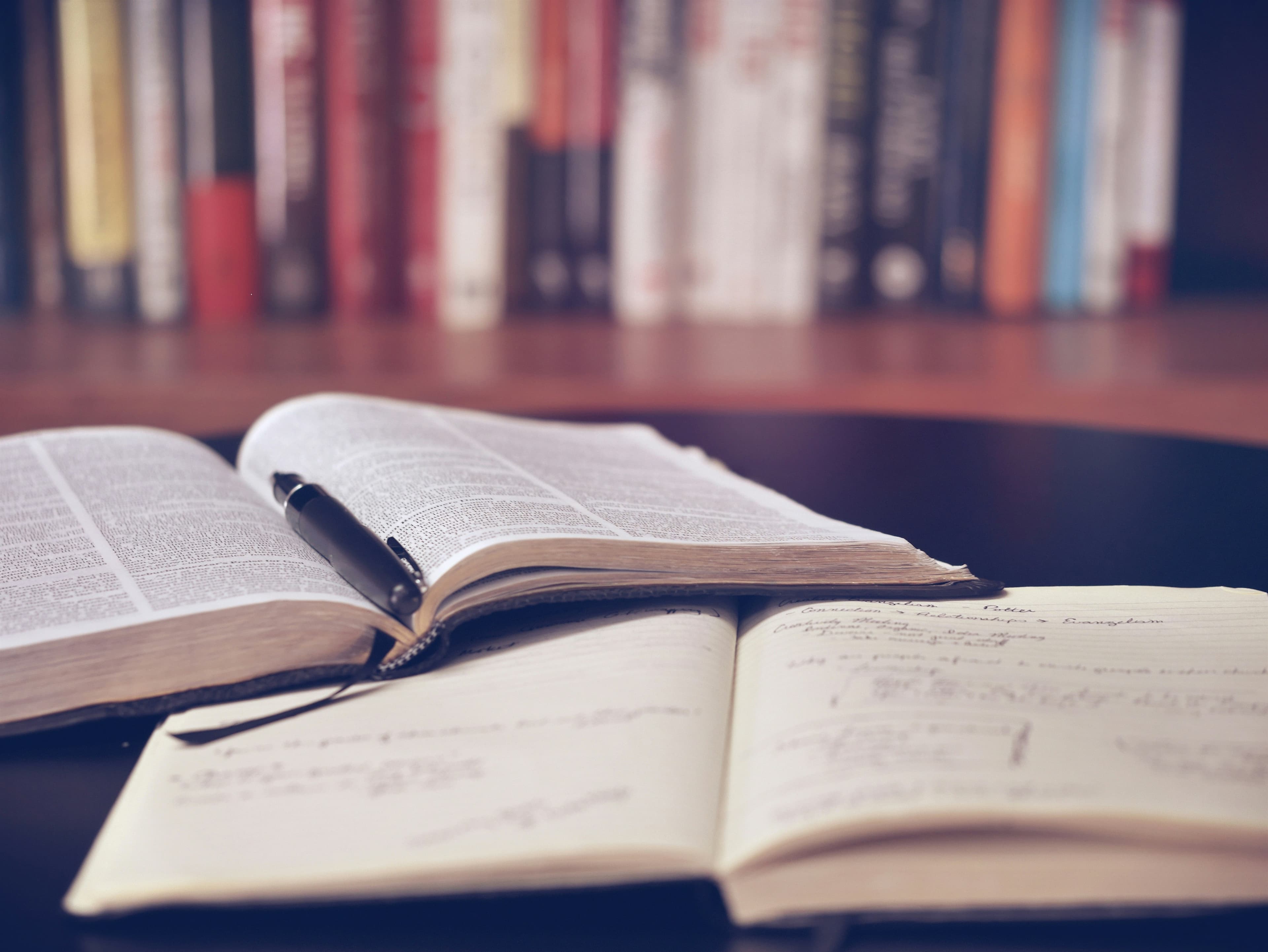 Illustrative open reference book, pen and written study notes