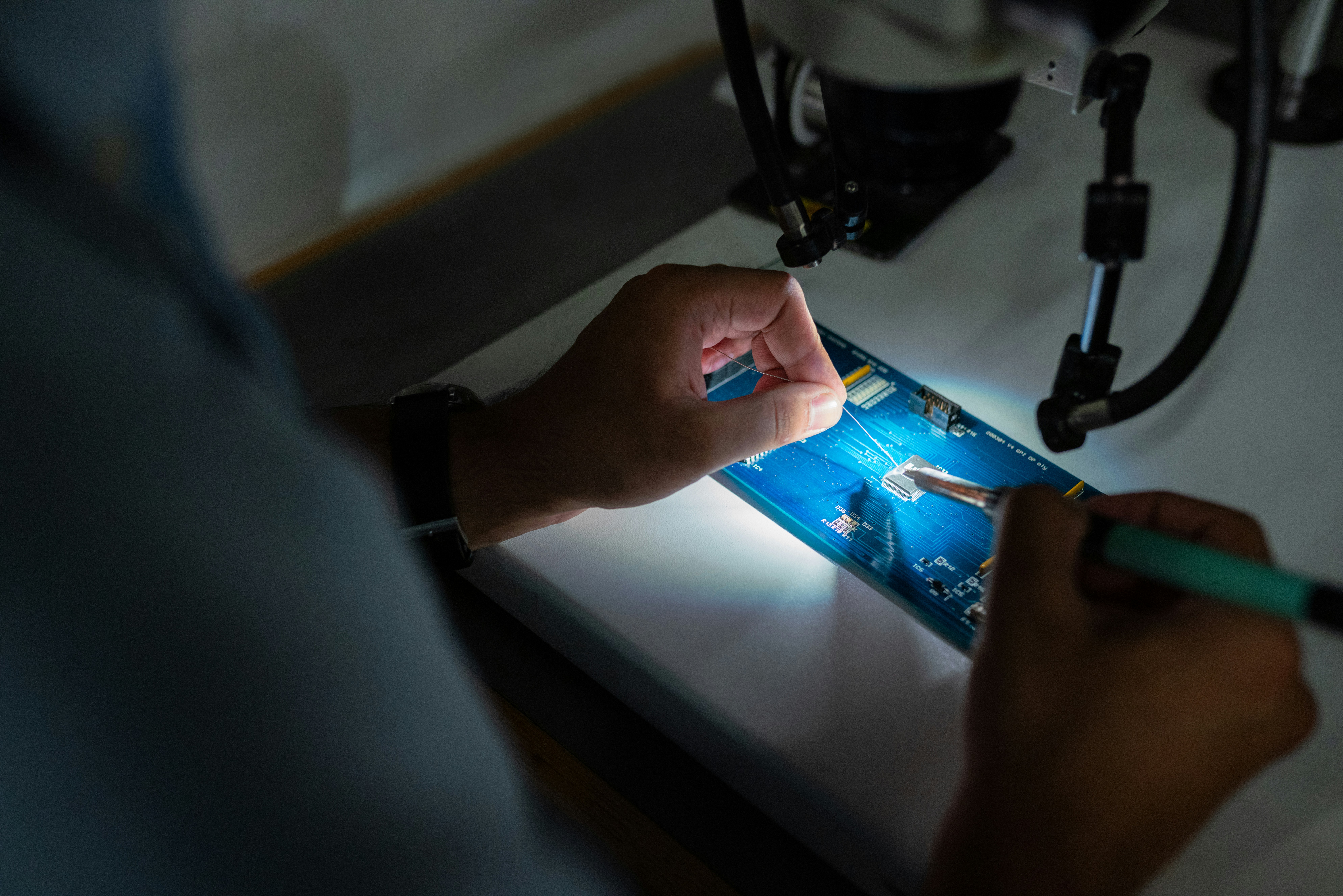 Engineer inspecting a circuit board under magnification